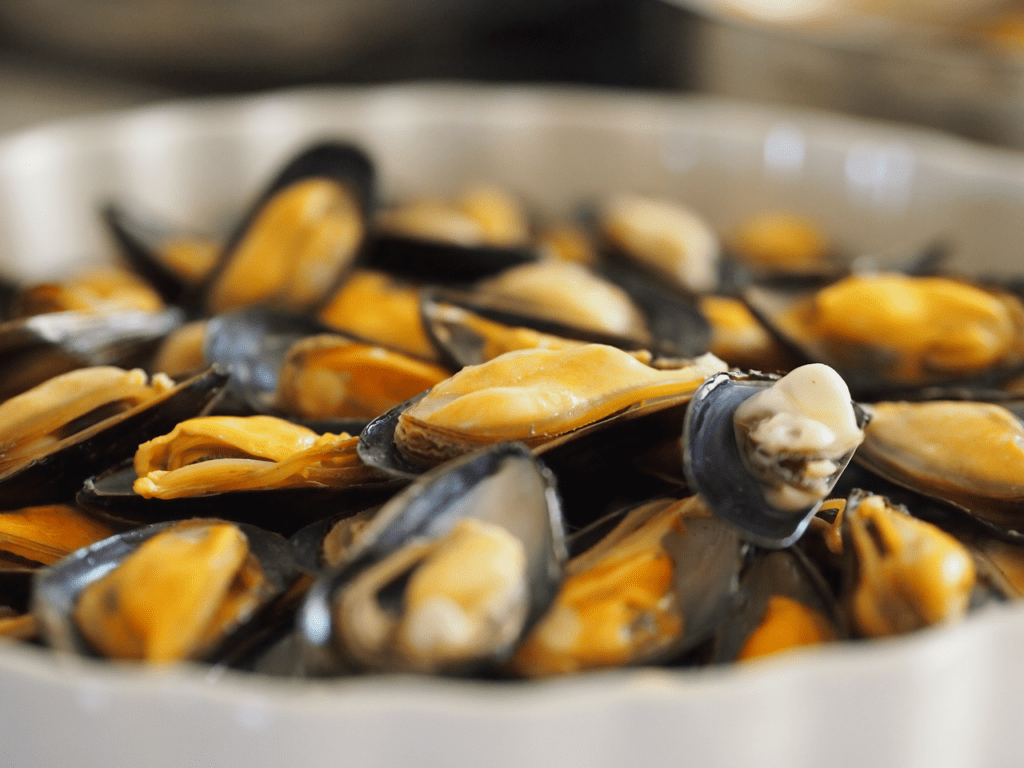 Close-up of fresh mussels served in a bowl, highlighting their rich texture.